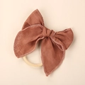 Close-up of a reddish-brown linen bow headband for girls with fine textured stitching - Orange