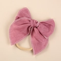 Close-up of linen bow baby headband with delicate white embroidery and nylon band - Deep Pink