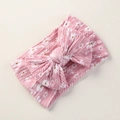 Detalle de diadema de punto rosa para bebé con estampado floral y lazo decorativo - Rosa oscuro