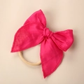 Close-up of rose red linen bow headband with detailed stitching and nylon elastic band - Rose Red