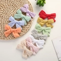 Flache Ansicht von elf bunten Schleifen-Haarspangen aus Jacquard-Baumwolle auf gewebter Matte - Zufällige Farbe