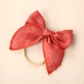Detailed macro view of the red linen bow headband with high-elastic nylon band for babies - Orange Red