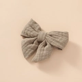 Close-up of cotton muslin bow hair clip featuring soft oat-colored woven fabric texture - Dark Khaki