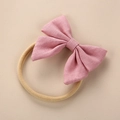 Detail showing pink linen bow attached to a high-elastic beige nylon baby headband - Light Pink