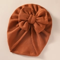 Detailed close-up of a ribbed knit baby hat with a large bow in caramel brown tone - 21*19 cm / Brown