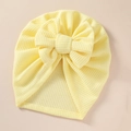 Close-up of baby turban hat featuring yellow waffle knit fabric and a large bow - 21*19 cm / Light Yellow