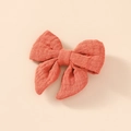 Gros plan d'un nœud à cheveux en coton mousseline rouge corail avec texture de tissu - Rouge Orangé