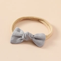 Détail d'un nœud en lin gris sur un bandeau souple en nylon pour bébé et texture - Gris clair