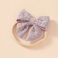 Detail of soft purple cotton bow on a beige nylon baby headband with fabric texture - Purple