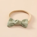 Détail d'un bandeau pour bébé avec nœud en lin vert clair et bande en nylon - Vert clair