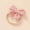 Detailed close-up of a soft pink cotton linen bow with elastic nylon headband for babies - Dusty Pink