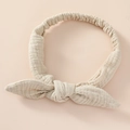 Detailed texture of beige cotton bow headband for baby with elastic back design - Khaki