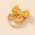 Detailed view of ginger cotton bow and soft elastic nylon headband for newborns - Turmeric