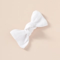 Detailed macro view showing the linen texture and knot on a white fabric hair bow clip - Pure White