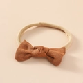 Dettaglio del fiocco in lino marrone per neonati con fascia elastica in nylon beige - Marrone