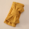 Close-up of bright yellow knitted baby headband featuring detailed hollow weave texture - Ginger Yellow