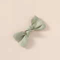 Detail of sage green linen bow hair clip showing premium cotton fabric texture - Light Green
