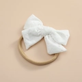 Détail du nœud en dentelle souple et du bandeau élastique en nylon pour bébé - Blanc