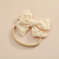 Dettaglio fascia per neonati in pizzo crema con fiocco e morbido nastro in nylon - Beige