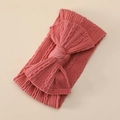 Detail of soft ribbed nylon baby headband with a large coral pink decorative bow - Brick Red