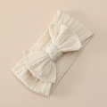 Detailed texture of soft cream jacquard nylon headband with large knit bow for infants - Off White