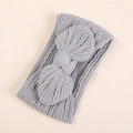 Dettaglio della fascia per neonata in nylon grigio chiaro con fiocco e trama morbida - grigio scuro