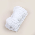 Close-up of white knitted baby headband with a large bow showing soft cable stitch texture - Bright White