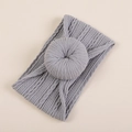 Dettaglio macro della fascia grigia per neonati con maglia a trecce jacquard e nodo a ciambella - Confezione OPP individuale / Grigio Scuro (#11)