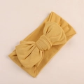 Detail of soft ginger yellow oversized bow headband with elastic knit fabric texture - Turmeric