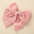 Macro detail of a light pink muslin cotton bow hair clip with textured fabric edges - 10.5x10.5cm / Watermelon Red