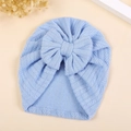 Detail of baby turban hat with chevron knit pattern and large decorative bow in light blue - M / Light Blue