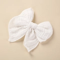 Close-up of white cotton muslin bow hair clip featuring soft textured fabric and stitched edges - 10.5x10.5cm / White