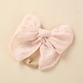 Detailaufnahme eines weichen Baby-Stirnbands mit hellrosa Baumwollschleife und Fransen - 10.5x10.5cm / Hellrosa