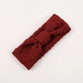 Gros plan du bandeau tricoté rouge foncé pour bébé avec texture torsadée et grand nœud - Bordeaux