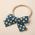 Dettaglio della fascia neonato in maglia blu con fiori gialli e morbido nylon - 9x6cm / Blu Navy Floreale Giallo