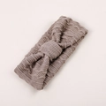 Détail d'un bandeau en tricot pour bébé avec nœud tressé en couleur mauve poussiéreux - Kaki