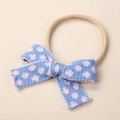 Detail of baby knitted bow headband with blue floral texture and soft nylon strap - 9x6cm / Light Blue With Pink Flowers