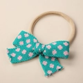 Detail of soft nude nylon headband featuring a sweet green and pink knitted floral bow - 9x6cm / Lake Blue Light Pink Floral