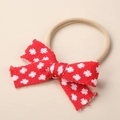 Close-up of a red knitted baby headband with white polka dots and soft texture - 9x6cm / Red White Floral