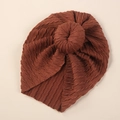 Detailed view of caramel knit baby hat with soft cable pattern and donut knot design - Brown