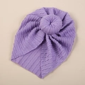Close-up of purple knitted baby turban hat with textured braid pattern and top knot ball - Purple