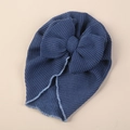 Detail of baby turban hat showing deep blue waffle knit fabric and large decorative bow - One Size / Navy Blue