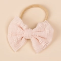 Detail view of a soft pink lace bow headband with nylon elastic for infants and toddlers - Light Pink