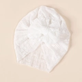 Detailed view of white baby turban featuring breathable lace floral pattern and large bow - White