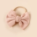 Detail of pink knitted bow with textured fabric on a soft nylon baby headband - Pink (#7)