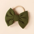 Close-up of a dark green ribbed knit bow on a soft nude nylon headband for infants - Dark Green (#10)