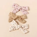 Vue détaillée de trois barrettes à fleurs en coton en rose, kaki et crème douce - Couleur Aléatoire
