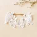 Détail de fleurs en dentelle blanche brodée sur un bandeau souple pour bébé fille - Style Fleurs Reliées Blanc