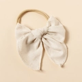 Détail de l'accessoire cheveux bébé en lin texturé avec bandeau élastique en nylon souple - Couleur Avoine