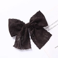 Vue détaillée d'une barrette nœud en dentelle multicouche avec texture mesh et bords festonnés - Noir